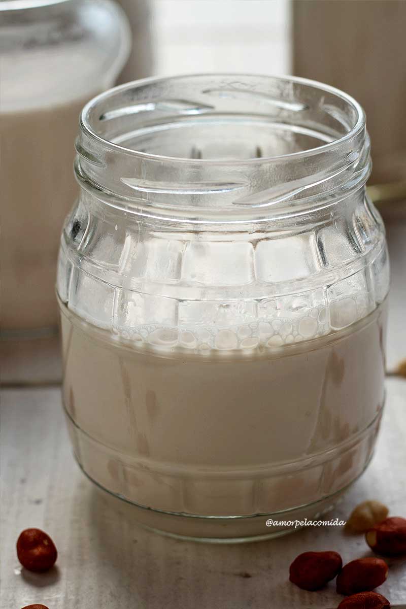 Vidro de conserva reciclado com leite de amendoim caseiro sobre mesa branca