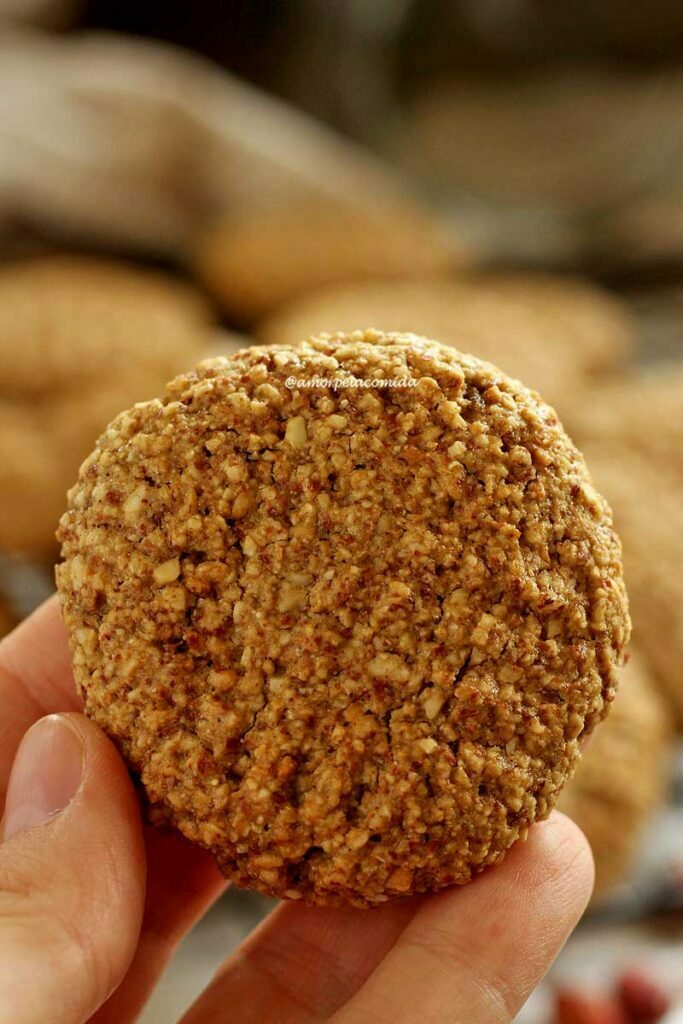 Mão segurando biscoito redondo de amendoim