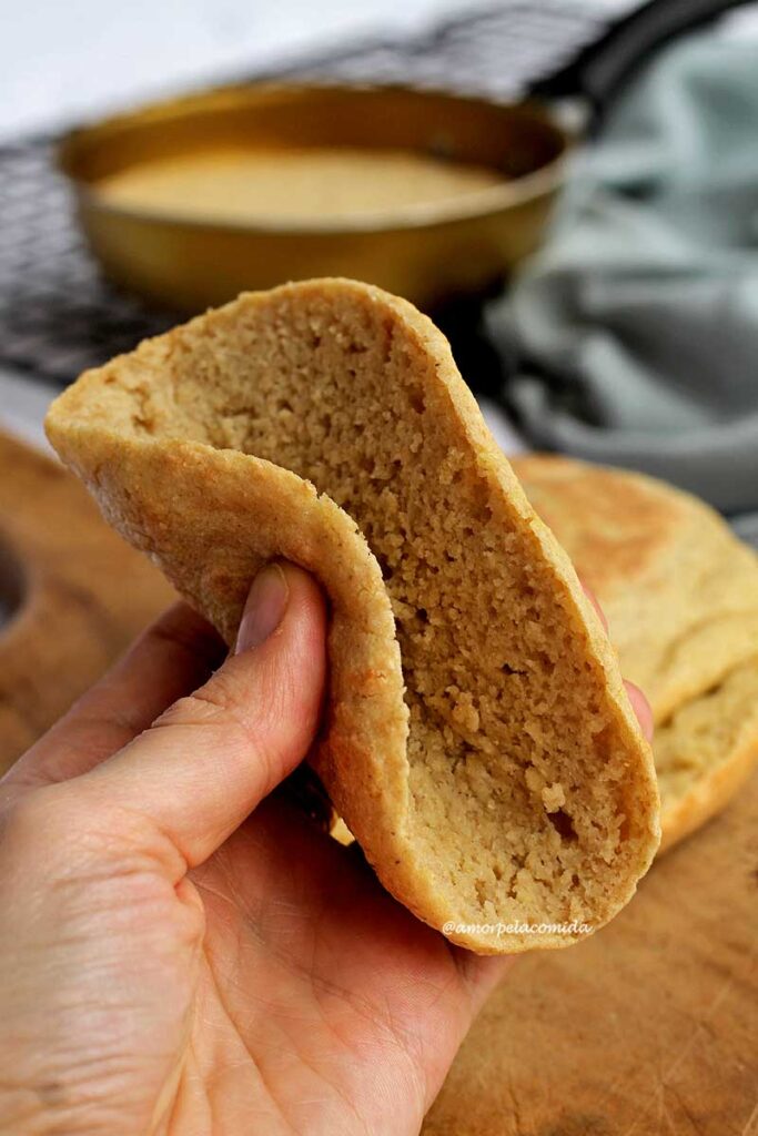 Pão dobrando fatia de pão redondo que foi assado na frigideira mostrando a flexibilidade da massa