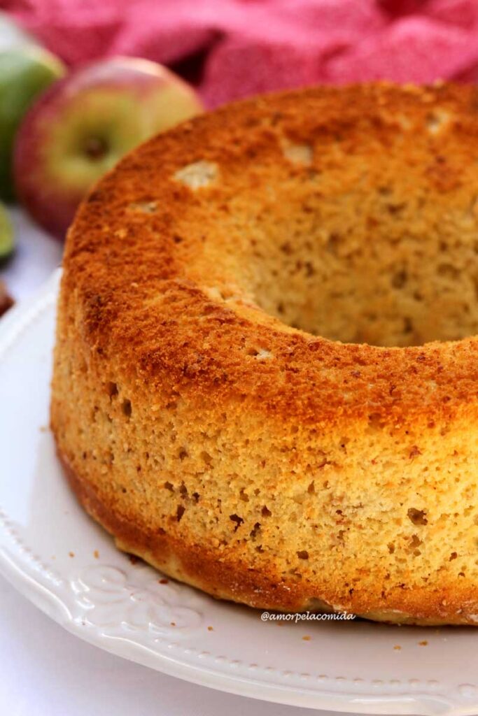 Bolo redondo com furo no meio, ao fundo uma maçã e algumas castanhas