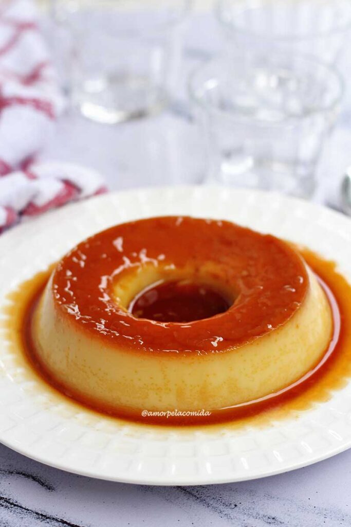 Pudim com todo caramelado, ao redor do pudim mais calda de caramelo