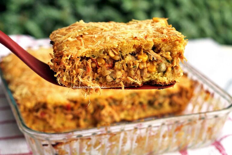 TORTA DE FRANGO DE LIQUIDIFICADOR SEM GLÚTEN Fatia de torta de frango na espátula sobre a torta de frango que foi assada em uma forma de vidro canelado