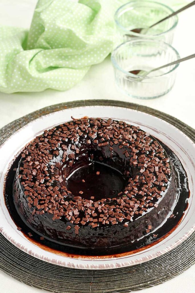 Pudim de chocolate com calda de chocolate e no topo do pudim granulado de chocolate