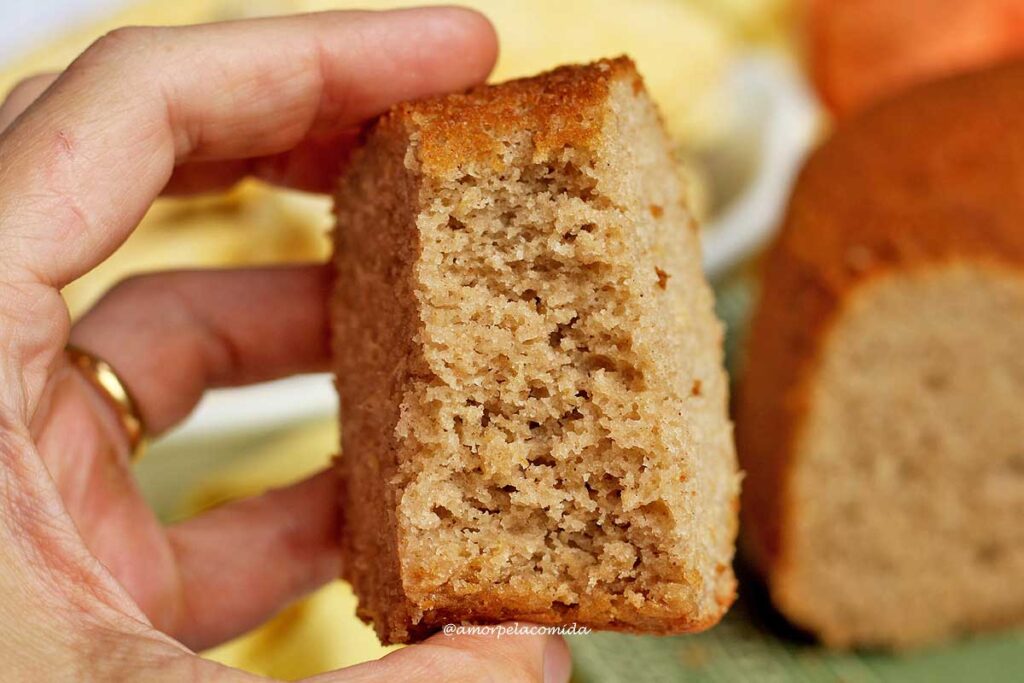 Mão segurando fatia de bolo mordido