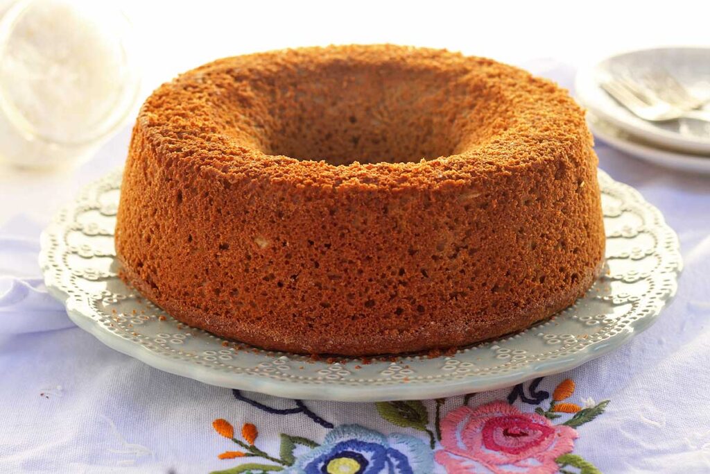 Bolo redondo com furo no meio sobre prato redondo com detalhes na borda