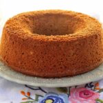 Bolo redondo com furo no meio sobre prato redondo com detalhes na borda