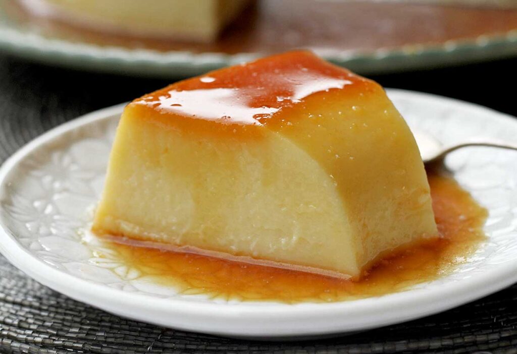Fatia de pudim com calda de caramelo sobre prato redondo pequeno