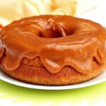Bolo redondo com furo no meio com doce de leite cremoso e bem generoso por cima