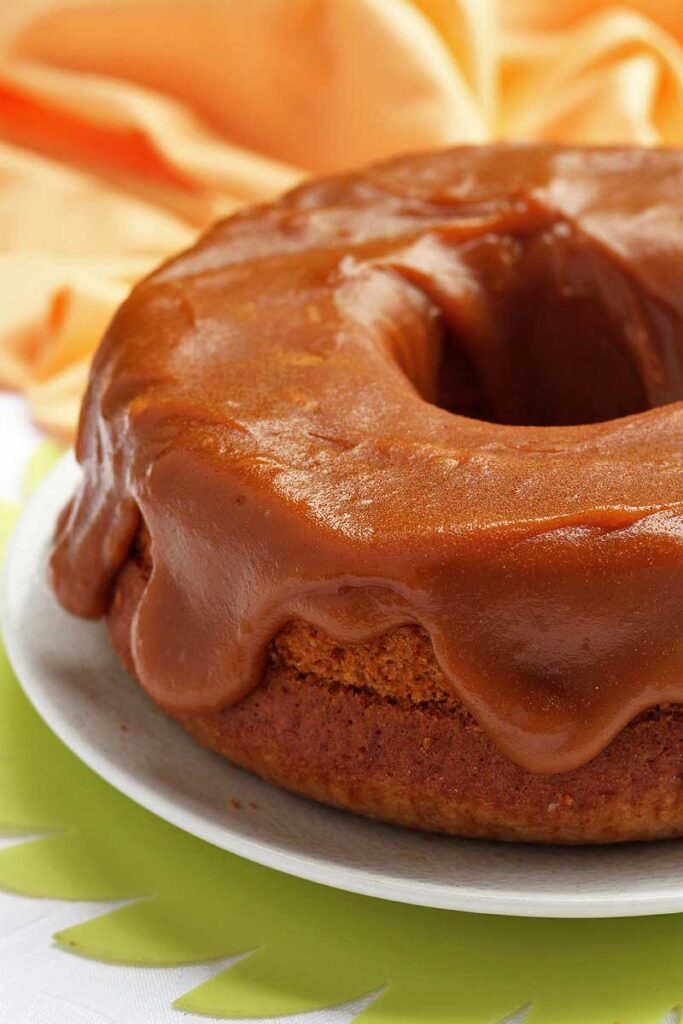 Bolo redondo com furo no meio com doce de leite cremoso e bem generoso por cima